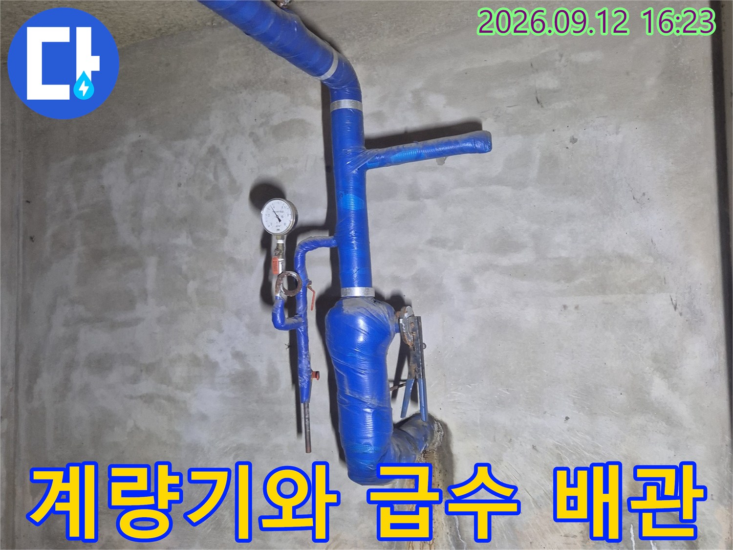 지하 시설물에-설치된 급수 계량기와 파란색 배관