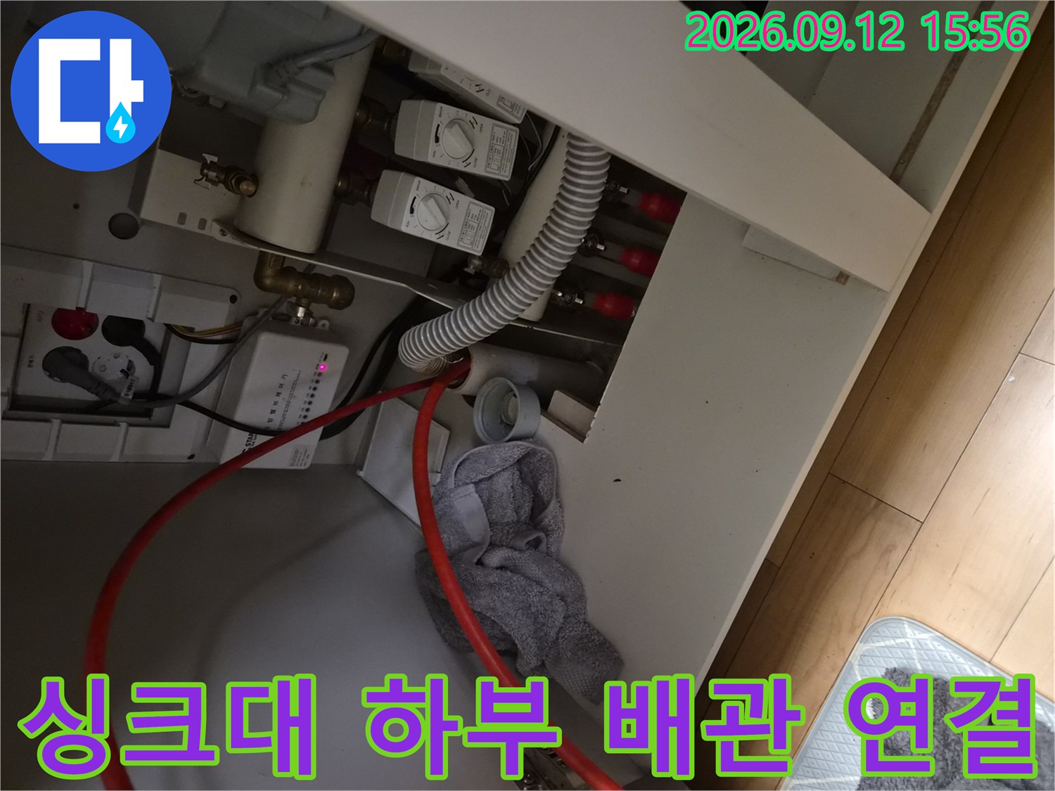 싱크대 밑부분의 급수 밸브와 주름진 배수 호스 모습