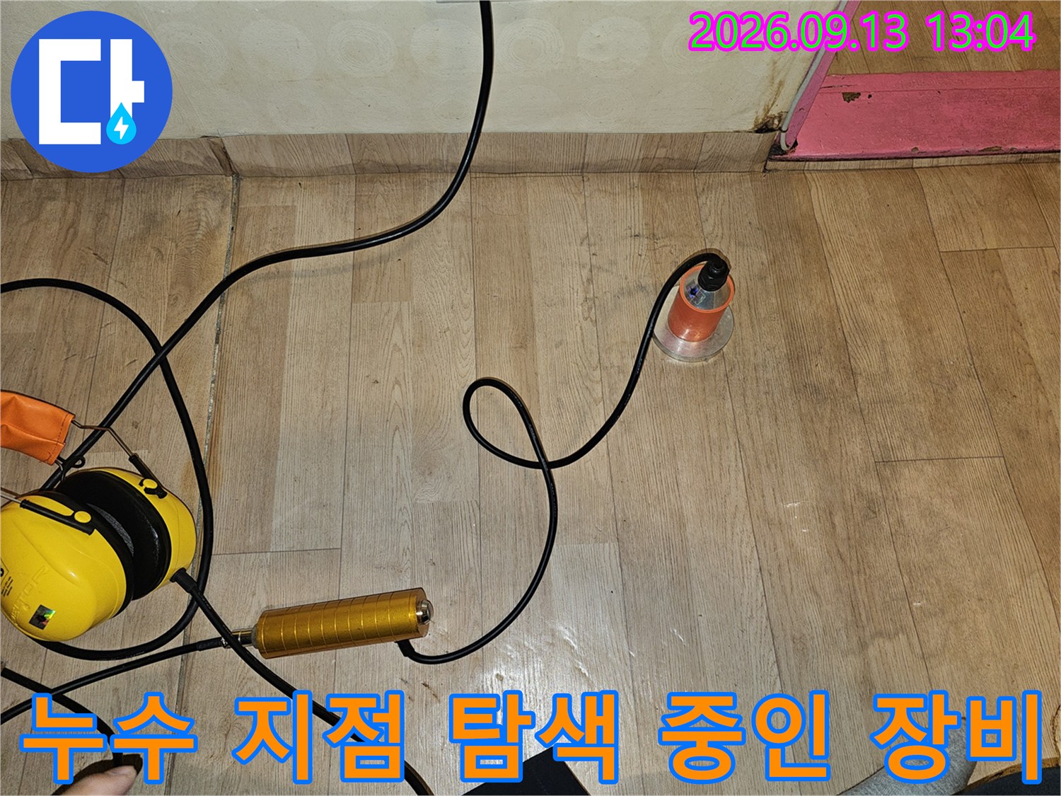 나무 바닥 위에서 누수음을 포착하기 위해 작동 중인 청음식 탐지기