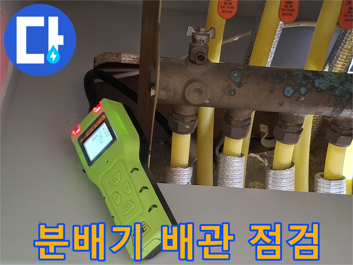 노란색 난방 배관과 분배기 연결 부위의 가스 탐지 작업 모습