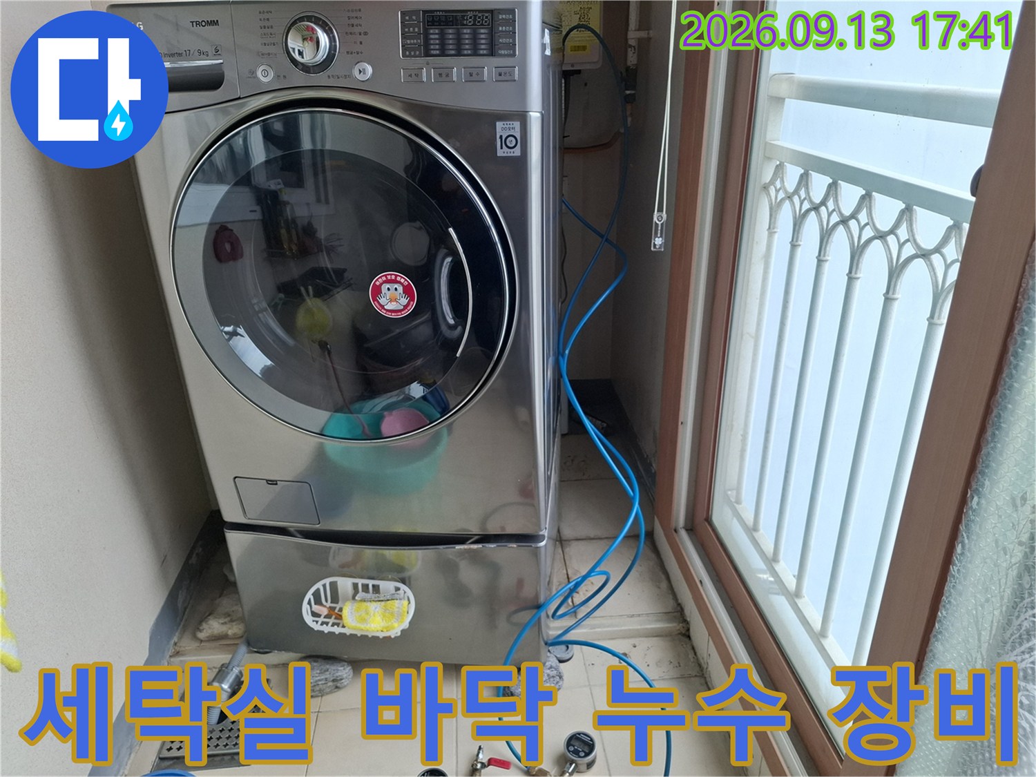 세탁기 옆 배수구 주변에 설치된 파란색 공압 테스트용 호스