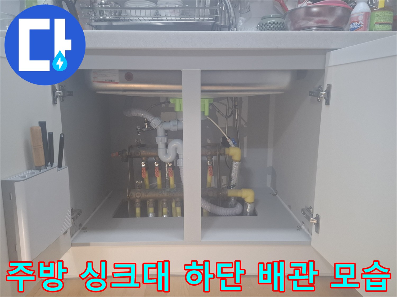 싱크대 밑에 설치된 난방 분배기와 엑셀 배관의 연결 상태