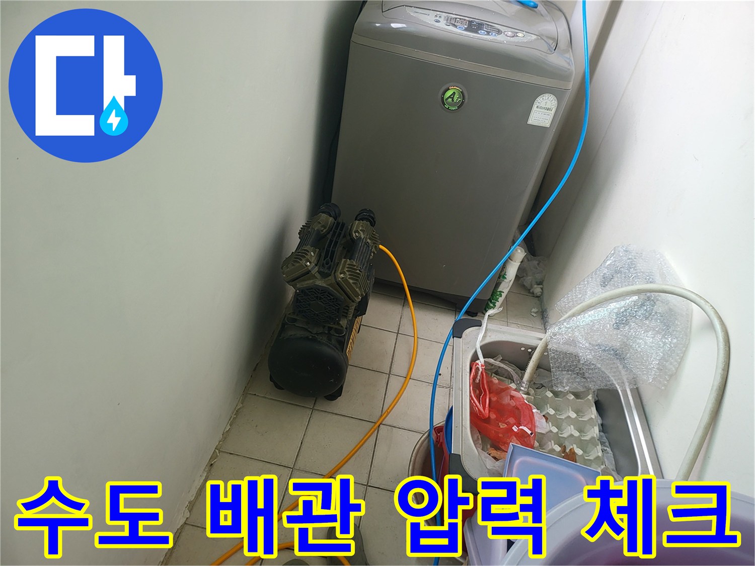 보일러와 연결된 배관에 공압 테스트기를 설치하여 점검하는 모습입니다.
