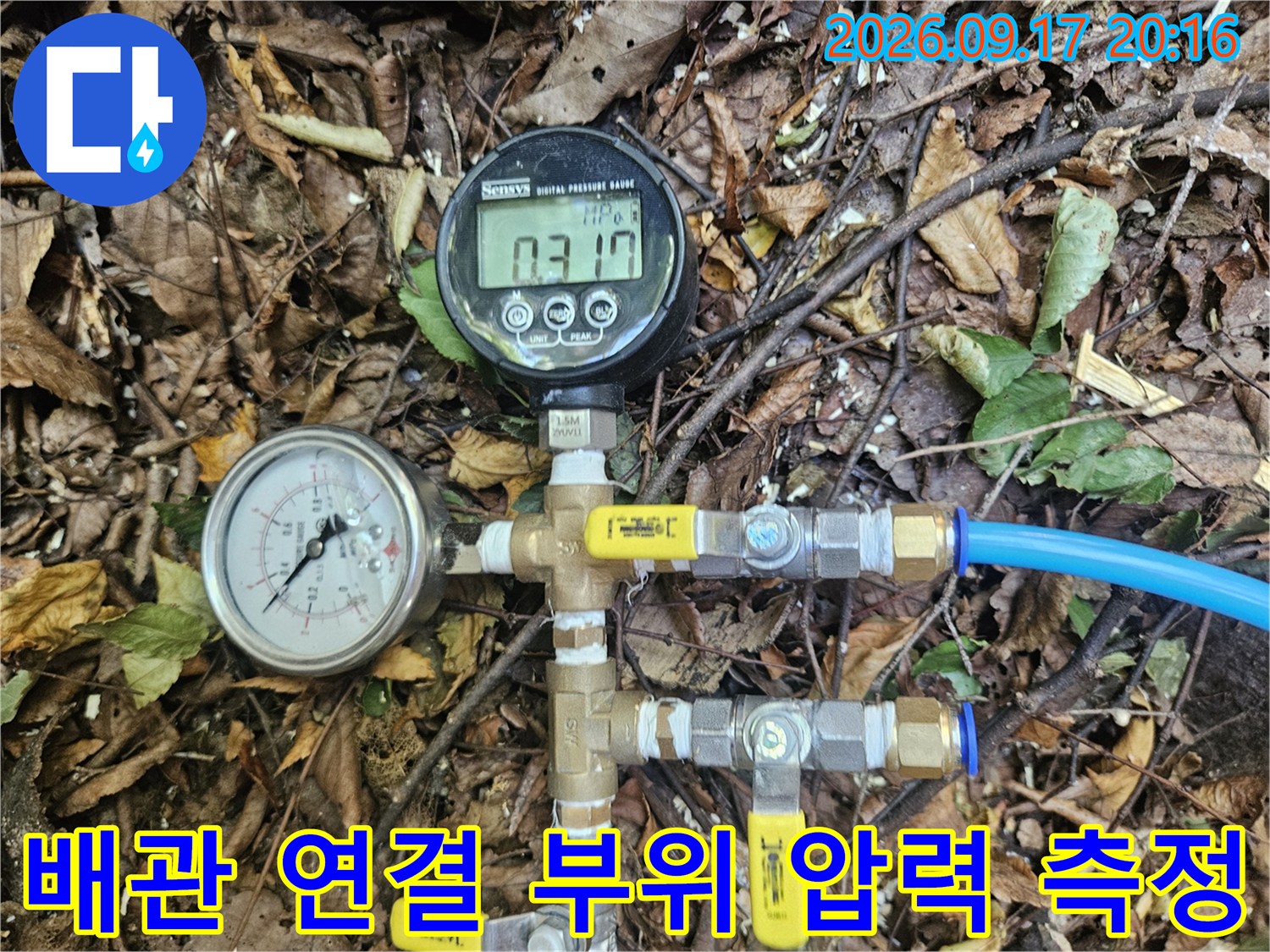 금속 부속과 파란색 배관에 연결된 압력 측정 장비 세트