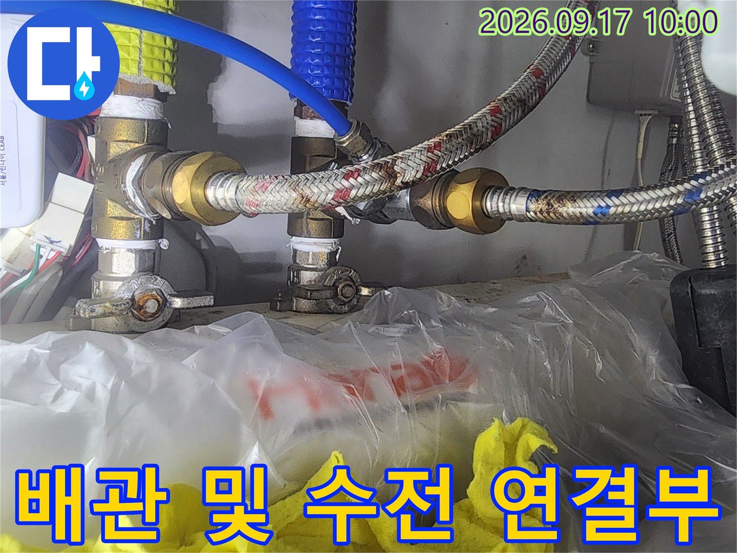 싱크대 하단에 설치된 금속 호스와 밸브의 결합 상태를 보여줍니다.