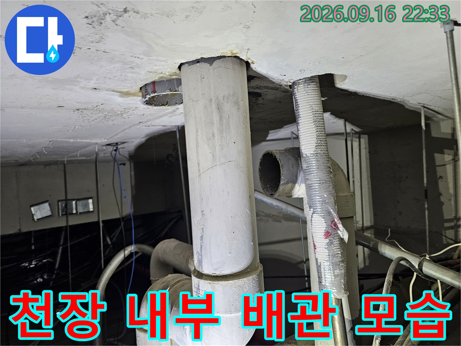 천장 마감재 아래로 드러난 노출 배관과 연결 부위의 상세 사진입니다.