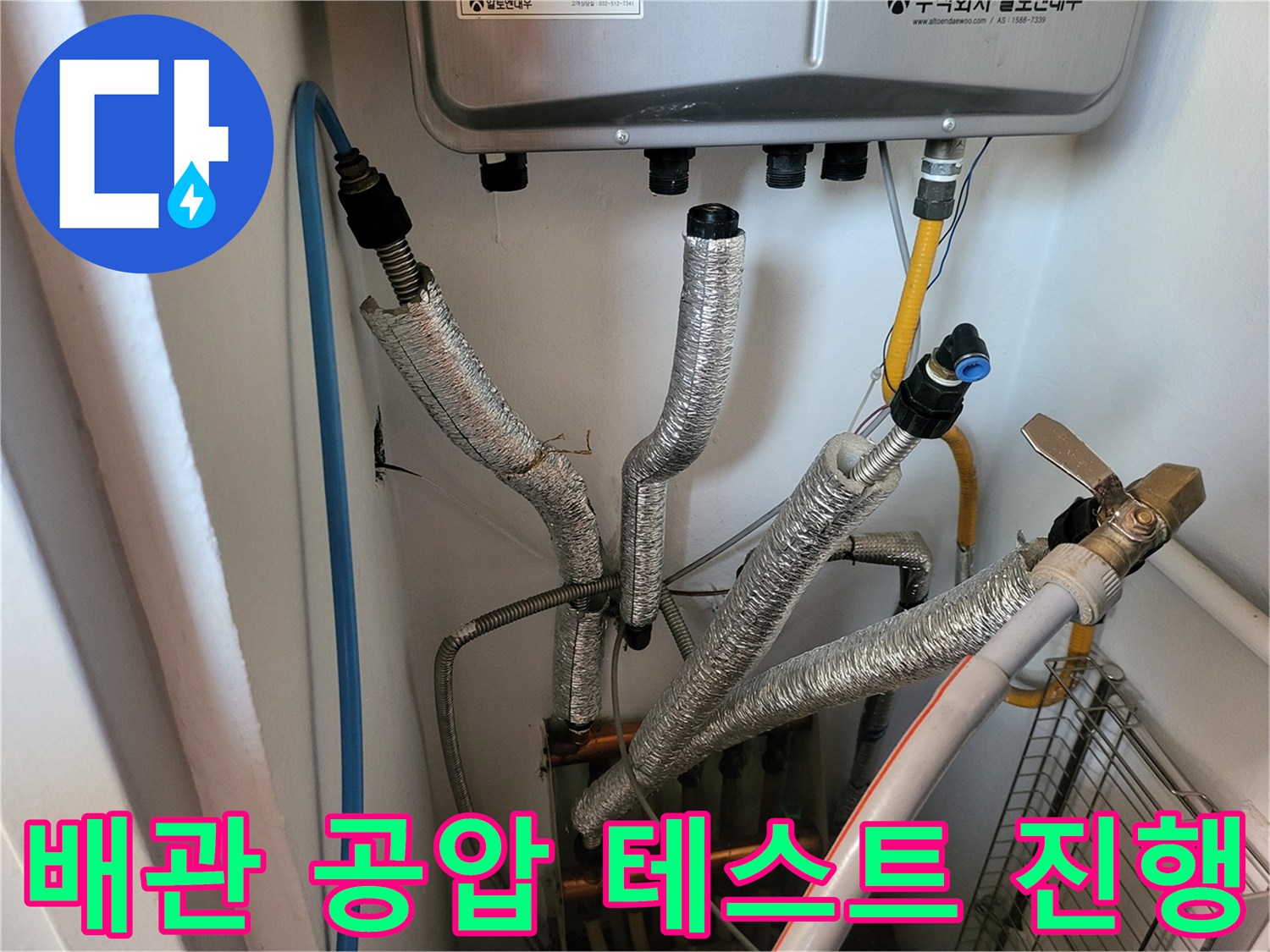 보일러 하단 배관 연결부에 압력계를 설치하여 검사하는 장면